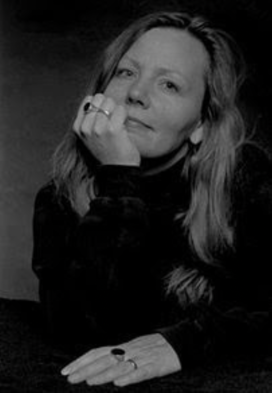 Headshot in black and white of a woman resting her chin in her hand